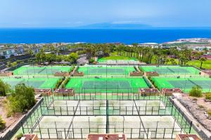 two tennis courts with the ocean in the background at Las Terrazas de Abama Suites in Guía de Isora