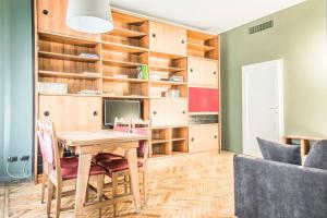 ein Esszimmer mit einem Holztisch und Stühlen in der Unterkunft Margreth Apartment in Mailand