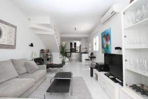 Una sala de estar blanca con un sofá y un televisor. en Casa grande familiar con 4 terrazas, en Las Palmas de Gran Canaria