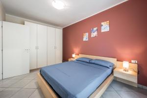 a bedroom with a blue bed and a red wall at Ampio trilocale con giardino privato - Free WiFi & Private Parking in SantʼAgata sul Santerno