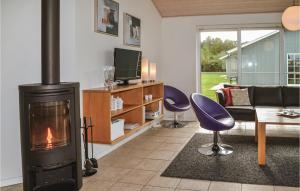 a living room with a fireplace and a couch at 4 Bedroom Cozy Home In Nrre Nebel in Lønne Hede