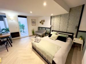 a large bedroom with a large bed and a desk at Le Petit Patio in Aix-en-Provence