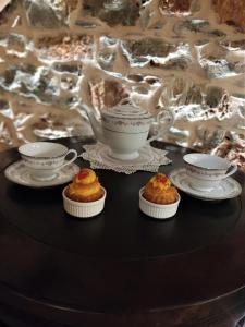a table with two tea cups and cupcakes on it at Angel's Suites 2 in Samos +21 photos