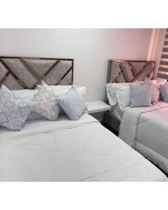 a bedroom with two beds with pillows on them at Apartasuite deluxe in Popayan