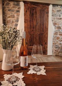 een fles wijn en twee wijnglazen op een tafel bij Angel's Suites 2 in Samos