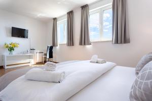Schlafzimmer mit einem großen weißen Bett und Fenstern in der Unterkunft Adriatic Queen Residence in Split