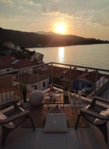 een balkon met uitzicht op het water en de zonsondergang bij Angel's Suites 2 in Samos