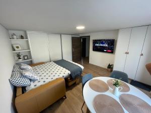1 dormitorio con 1 cama, mesa y sillas en Home-in apartma, en Liubliana