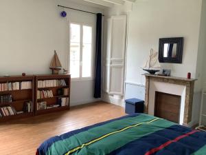 1 dormitorio con 1 cama, chimenea y ventana en Demeure XIXe Beauval-en-caux, 