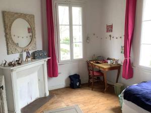 1 dormitorio con cama, mesa y espejo en Demeure XIXe Beauval-en-caux, 