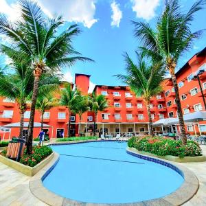 una piscina frente a un hotel con palmeras en Lagoa Quente Hotel - LAGOA OFICIAL, en Caldas Novas