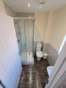ein Bad mit einer Dusche, einem WC und einem Waschbecken in der Unterkunft S&J Lodge in Peterborough
