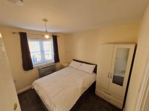 ein kleines Schlafzimmer mit einem Bett und einem Fenster in der Unterkunft S&J Lodge in Peterborough