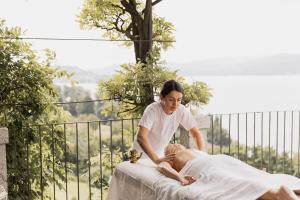 Eine Frau, die einer Frau eine Massage auf einem Bett gibt. in der Unterkunft Villa Antica Colonia - Lake Orta - Suite Apartments Adults Only - SPA & Wellness in Pettenasco