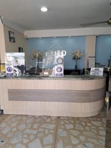 a lobby with a reception counter with purple signs at Hotel Exito Barranquilla in Barranquilla
