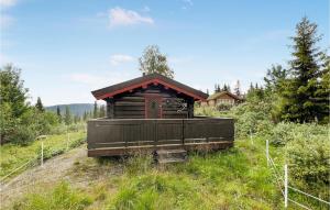 a small cabin in the middle of a field at Beautiful Home In Nord-torpa With House A Mountain View in Nord Torpa