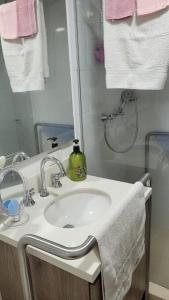 a bathroom with a sink and a shower with towels at Apartamento en Sabaneta in Sabaneta