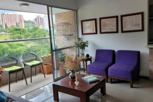 uma sala de estar com duas cadeiras roxas e uma mesa em Apartamento en Sabaneta em Sabaneta