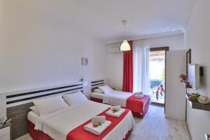 a hotel room with two beds and a window at Antiphellos Pension Küçükçakıl in Kas