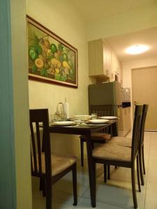 einen Tisch und Stühle in einer Küche mit einem Gemälde an der Wand in der Unterkunft Our Happy Place Among the Sky in Tagaytay