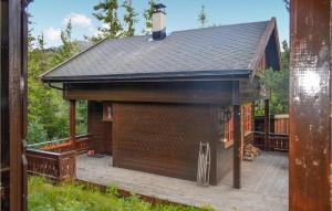 a large brown building with a deck and a roof at Stunning Home In Rjukan With House A Mountain View in Rjukan
