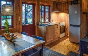 a kitchen with a table and a refrigerator at Stunning Home In Rjukan With House A Mountain View in Rjukan