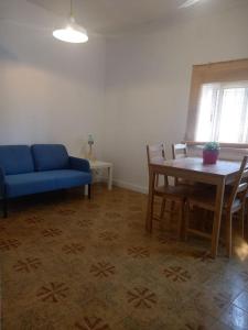 a living room with a blue couch and a table at Acogedor apartamento a 10min de PortAventura. in Tarragona
