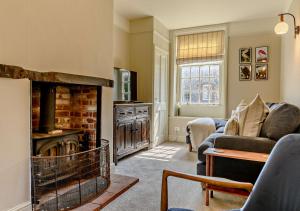 謝林漢姆的住宿－Foxes Retreat，带沙发和壁炉的客厅