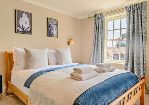 謝林漢姆的住宿－Foxes Retreat，一间卧室配有一张大床和毛巾