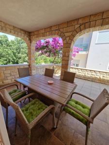 a wooden table and chairs on a patio at Villa Luka in Barbariga