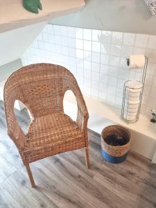 een rieten stoel in een badkamer met een wastafel bij Hafan Artro in Llanbedr