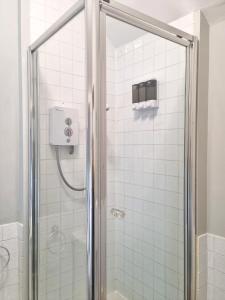 y baño con ducha y puerta de cristal. en Hafan Artro en Llanbedr