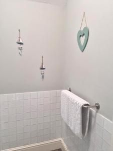 a white bathroom with a blue heart on the wall at Hafan Artro in Llanbedr