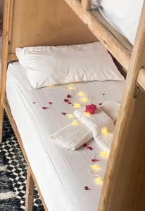 a bed with flower petals on it at Boho 27 Hostel Marrakech in Marrakesh