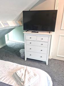 a white dresser with a flat screen tv on top of it at Hafan Artro in Llanbedr