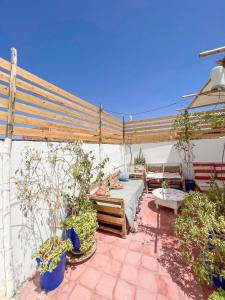 eine Terrasse mit einem Bett und einigen Topfpflanzen in der Unterkunft Boho 27 Hostel Marrakech in Marrakesch