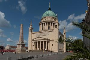 a large white building with a green dome and a steeple at Studio Apartment im Palais Fleur Blanche in Potsdam