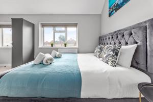 um quarto com uma grande cama branca com almofadas em Cozy Serviced Room in Feltham Heathrow London TW13 em Feltham