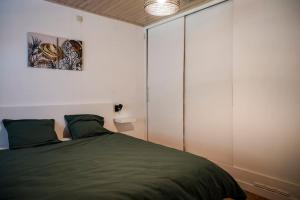 1 dormitorio con cama verde y pared blanca en Villa spacieuse et accueillante, en Mons