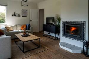 sala de estar con sofá y chimenea en Villa spacieuse et accueillante en Mons