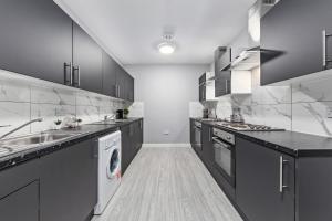 a large kitchen with a sink and a dishwasher at Cozy Serviced Room in Feltham Heathrow London TW13 in Feltham