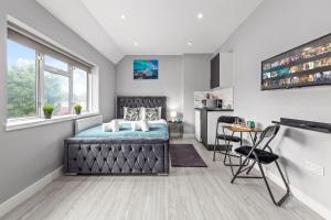 1 dormitorio con cama, ventana y mesa en Cozy Serviced Room in Feltham Heathrow London TW13, en Feltham