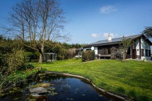 een huis met een vijver voor een tuin bij Villa spacieuse et accueillante in Bergen