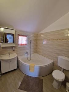 La salle de bains est pourvue d'une baignoire, de toilettes et d'un lavabo. dans l'établissement Villa Luka, à Barbariga