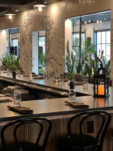 um restaurante com mesas, cadeiras e plantas em The Federal em Brunswick