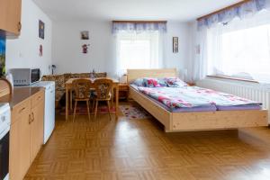 ein Schlafzimmer mit einem Bett und einem Tisch sowie eine Küche in der Unterkunft Apartmaji Verica Ceklin in Bohinj