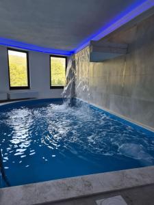 une grande piscine intérieure avec une fontaine dans l'établissement Holiday Resort Zlatni Dol Mostar, à Goranci
