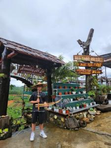 a man standing in front of a stand with abow at Hà Lù Homestay in Lao Cai