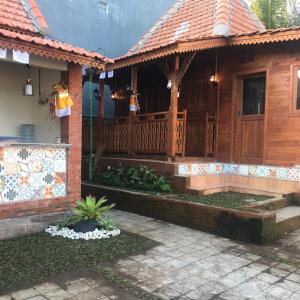 Casa con porche de madera con terraza en Bharata Beach House, en Keramas