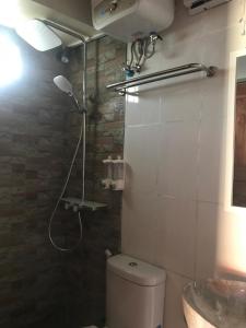 y baño con ducha, aseo y lavamanos. en Bharata Beach House, en Keramas